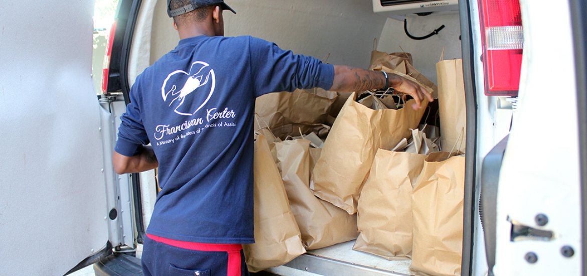 Worker from Franciscan Center loads van that delivers meals to homeless